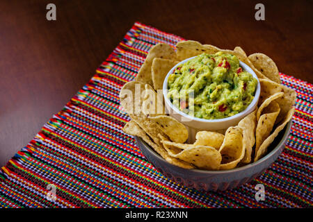 Mais Nacho Chips und Avocado guacamole Dip in einer Schüssel über einem Tisch Stockfoto