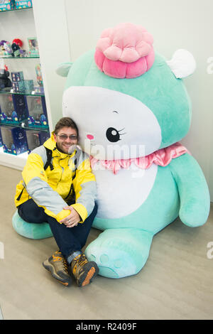 Reykjavik, Island - 12. Oktober 2017: Mann Reisender mit hello kitty Spielzeug. Urlauber Mann. Hallo, stattlich. Hello Kitty ist eine Zeichentrickfigur, die von dem japanischen Unternehmen hergestellt. Stockfoto