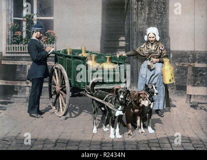 Flämische Milch Hausierer stand neben ihr zwei-Rad-Wagen beladen mit Milchkannen, mit drei Hunden, die nach vorne und ein Mann in Uniform in Antwerpen, Belgien 1895 genutzt Stockfoto