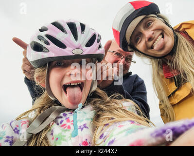 Eine Nahaufnahme selfie einer glücklichen Familie mit einem Kind, sie sind auf einem im bikeride und Ziehen dumme Gesichter. Stockfoto