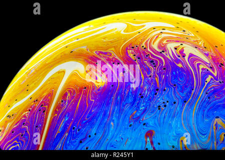 Nahaufnahme Regenbogen Farben in einer Seifenblase, wie Leerzeichen oder Planeten oder Welten auf einem schwarzen Hintergrund isoliert betrachten Stockfoto