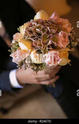 Bräutigam Holding in die Hände zarte, teuer, trendy Braut Hochzeit Blumenstrauß. Stockfoto