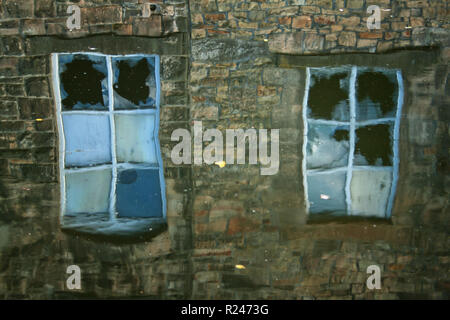 Die Reflexion der zerbrochene Fenster, an der Seite der Leeds und Liverpool Canal, Brierfield Stockfoto