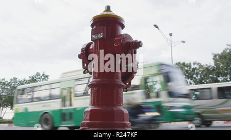 Red Fire hydrant Pole auf der Straße Ho Chi Minh Stadt. Neben der Straße und vorbeifahrende Autos und Motorräder. Vietnam. Stockfoto