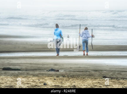 Cannon Beach, Oregon, USA - September 28,2010: Zwei junge Frauen, clam Graben an einem nebligen Strand bei Tolovana Beach in Cannon Beach, Oregon. Stockfoto