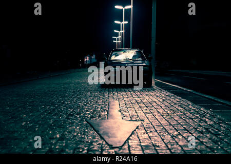 Auto auf gepflasterten Straße mit Pfeil in dunklen spooky Street zeigt, Zadar, Kroatien Stockfoto