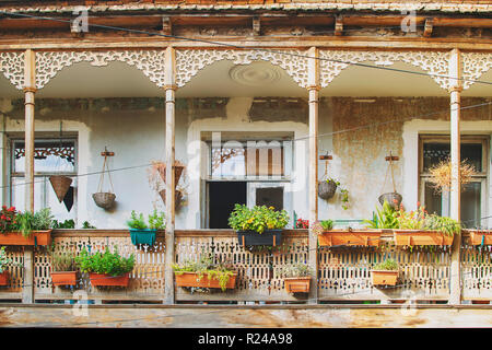 Altes Haus in Tiflis, Georgien mit schöner Terrasse. Alte traditionelle hölzerne Balkon mit vielen Blumen und alten Artefakten dekoriert Stockfoto