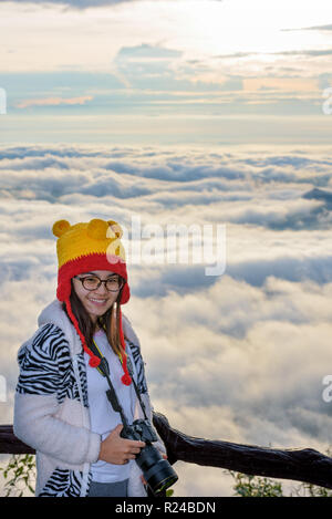 Frau touristische Holding eine DSLR-Kamera auf schöne Natur Landschaft der Nebel ist wie das Meer im Winter bei Sonnenaufgang Hintergrund bei hohen Aussichtspunkt Phu Stockfoto