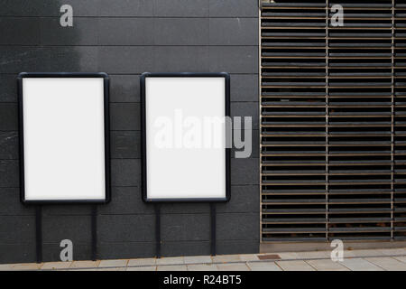 Zwei leere Plakate für Werbung, gegen eine schwarze Wand Stockfoto