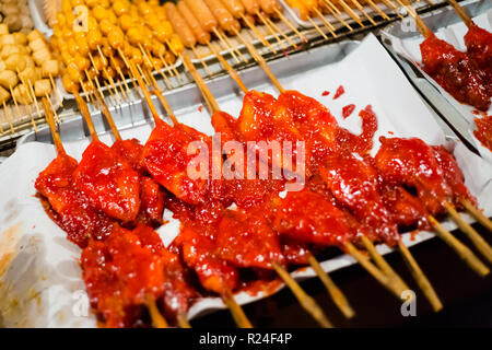 Frischen asiatischen pikante Huhn und Schwein am Spieß Grillen auf lokalen Nachtmarkt Saladan auf Koh Lanta Island. Traditionelle thailändische Küche aus frischen ingredie Stockfoto