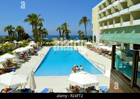 Touristen, die um den Pool im Louis Imperial Beach Hotel Stockfoto