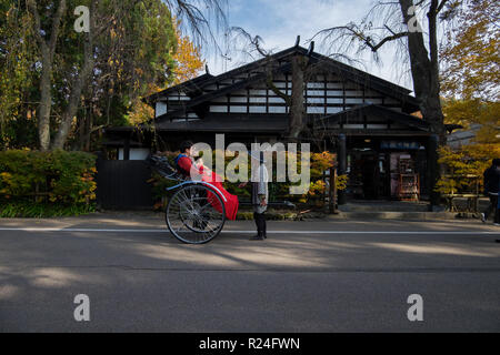 Eine Rikscha entlang Bukeyashiki Straße in Hakuba, Japan während der Fallhöhe Farbe. Stockfoto