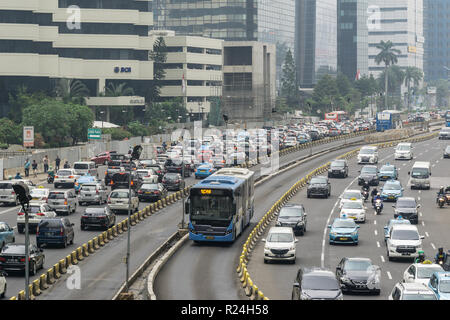 Jakarta, Indonesien - 09. November 2018: eine transjakarta Bus verwendet eine eigene Fahrspur Heavy Traffic Jam im Herzen von Jakartas Business Distri zu vermeiden. Stockfoto