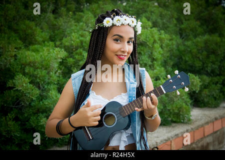 Vorderansicht eines jungen schönen Mädchen mit geflochtenem Haar, spielen der Ukulele Stockfoto