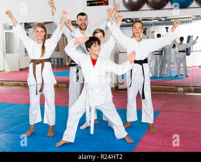 Portrait von glückliche Kinder und männliche Trainer in kimonos vor Karate Training Stockfoto