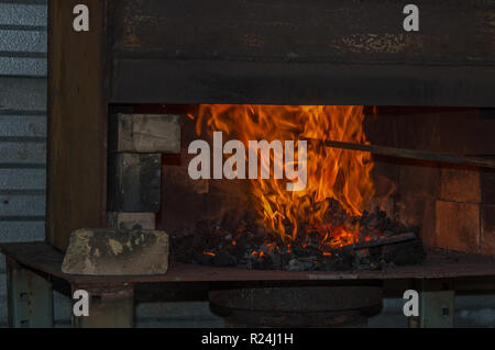 Ein Feuer lodert heiß in der Kohle in der bladesmith shop Forge Stockfoto