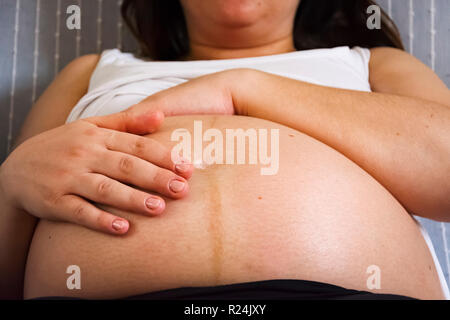 Hände einer schwangeren Frau, Ihren Bauch streicheln. Neues Leben Konzept Stockfoto