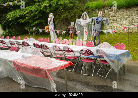 Regengetränkte Tische Vogelscheuchen-Bilder der königlichen Familie auf einer Straßenparty zum offiziellen 90. Geburtstag von Königin Elizabeth II Stockfoto