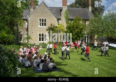 Schüler tanzen im Garten von Dorchester Abbey, Oxfordshire, um die Maypole herum Stockfoto