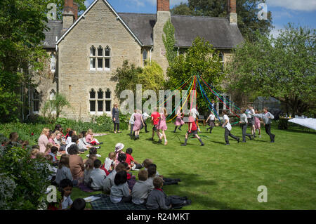 Schüler tanzen im Garten von Dorchester Abbey, Oxfordshire, um die Maypole herum Stockfoto