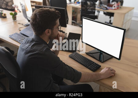 Männliche Exekutive arbeiten am Schreibtisch Stockfoto