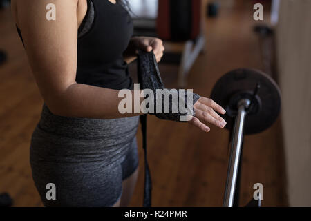 Weibliche Boxer tragen Hand wickeln im Fitness Studio. Stockfoto