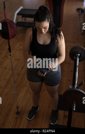 Weibliche Boxer tragen Hand wickeln im Fitness Studio. Stockfoto