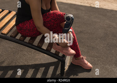 Behinderte Frau Schnürsenkel binden Stockfoto