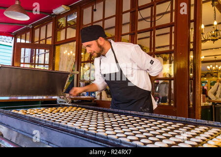 Arnhem, Niederlande - November, 04, 2018: Mann backen traditionelle niederländische Poffertjes poffertjes in einem alten Stall Stockfoto