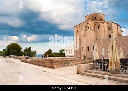 Kirche St. Donatus und die Gasse, das Forum Platz und steinerne Ruinen, Bäume und Wände an einem Sommermorgen. Dramatische Wolkenhimmel. Einsam und gemütliche Zadar Stockfoto