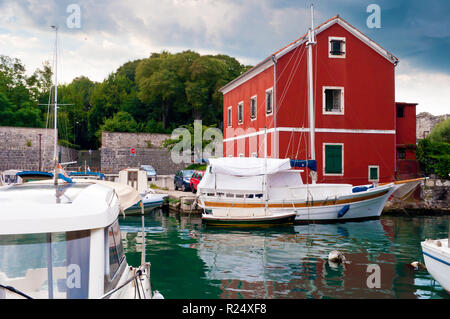 Gemütliche malerische Stadt Zadar, Kroatien. Rotes Haus unter grünen Bäumen, in der Nähe von Emerald Wasser wo Yachten schweben. Dramatische bewölkten Morgen sky Stockfoto