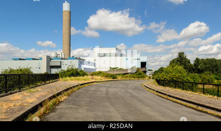 London, England, UK - 28. Juli 2013: Eine überwachsene Straße verläuft neben London EcoPark, 1970er Waste-to-energy Verbrennungsanlage power station in Edmonton. Stockfoto