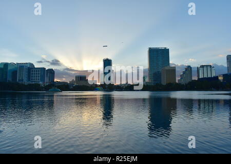 Orlando, Florida. Oktober 19, 2018 Sonnenuntergang mit Sonnenstrahlen am Horizont an Eola Lake Park. Stockfoto