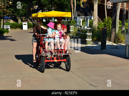 Orlando, Florida; Oktober 10, 2018 Familie mit zwei hübsche Mädchen, genießen sie eine Fahrt mit Surrey Fahrrad in der Lake Buena Vista Gegend. Stockfoto