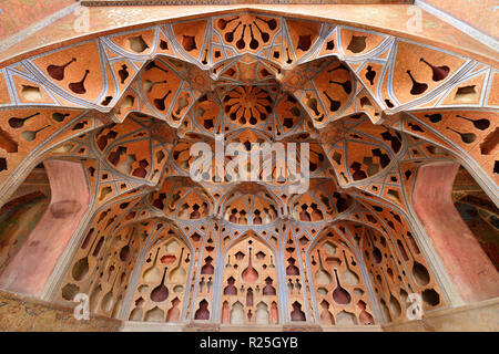 ESFAHAN, IRAN - 26. OKTOBER 2018: gemusterte Decke Kontraste mit Formen der Musik instrumente im Ali Qapu Palast, bei Naqsh-e Jahan Square gelegen Stockfoto