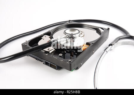 Wiederherstellung und Reparatur TECHNIK KONZEPT: Festplatte (HDD) mit Stethoskop isoliert auf Weiss. Stockfoto