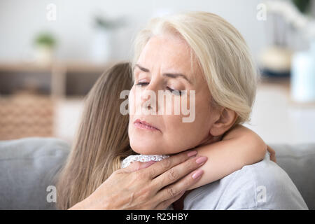 Lieben traurigen Großmutter umarmt kleines Mädchen tröstend Supporti Stockfoto
