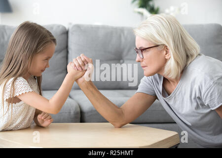 Alte Oma und Enkelin Arm Wrestling spielen toget Stockfoto