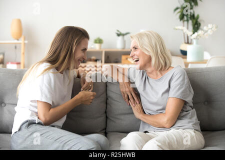 Freundliche alte Mutter und junge erwachsene Tochter reden lachen Stockfoto