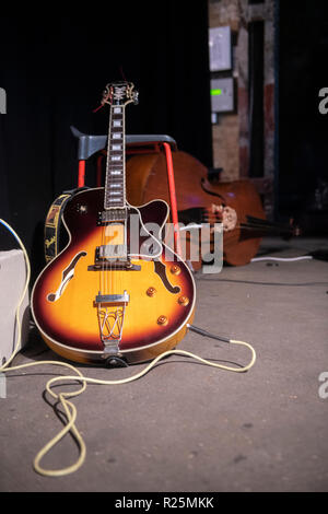 Eine semi-akustische Gitarre und Amp auf der Bühne vor einem Konzert Stockfoto