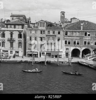 1950er Jahre, historische Ansicht von Venedig, der berühmte italienische Stadt der kleinen Inseln oder Lagunen durch Kanäle in der nördlichen Region Venetien getrennt. Spannend und romantisch, die Stadt ist voll von historischen Kirchen, Palazzi, alte Brücken und Monumente und natürlich den berühmten Gondeln, die traditionelle, flachen Venezianischen Ruderboote hier gesehen, die Waren von einem Teil der Stadt zu einem anderen. Stockfoto