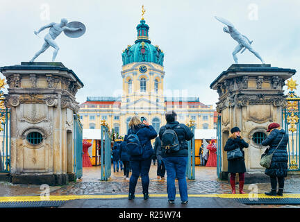 Berlin, Deutschland - Dezember 9, 2017: Menschen mit Rucksack Fotos am Weihnachtsmarkt am Schloss Charlottenburg im Winter Berlin, Deutschland. Christkindlmarkt Dekoration und Ständen mit Kunsthandwerk Produkte Stockfoto