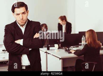 Junge Unternehmer im Büro auf Hintergrund mit Kollegen Stockfoto