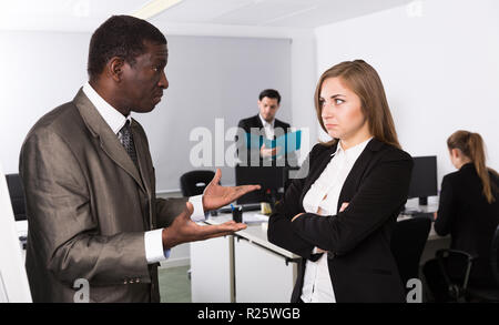 Unglückliche Frau Manager hören wütenden Mann Chef pointinting zu vermisst in Arbeit Stockfoto