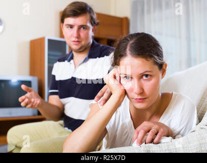 Unglückliche Frau, die versucht, mit meinem Mann zu versöhnen und hören sein Argument im Innenbereich Stockfoto