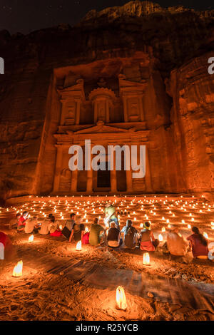 Die Menschen sitzen vor der Kerzen, der Schatz des Pharao Haus in Rock in der Nacht geschlagen, Fassade des Schatzhaus Al-Khazneh, Stockfoto