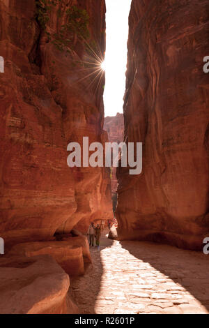 Touristen, die sich in der Schlucht Siq, Straße der nabatäischen Stadt Petra, in der Nähe von Wadi Musa, Jordanien Stockfoto