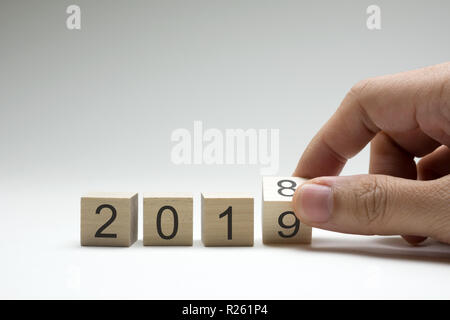 Hand dreht eine hölzerne Würfel symbolisch Änderungen von 2018 bis 2019 Stockfoto