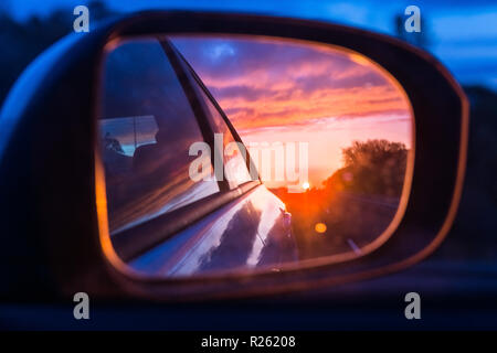 Feurigen Sonnenuntergang am Außenspiegel des Autos gesehen Stockfoto