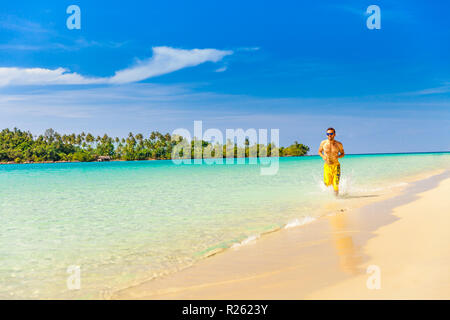 Aktiven Lifestyle und Travel Concept: schöner Mann in Sonnenbrille entlang tropischer Strand Stockfoto